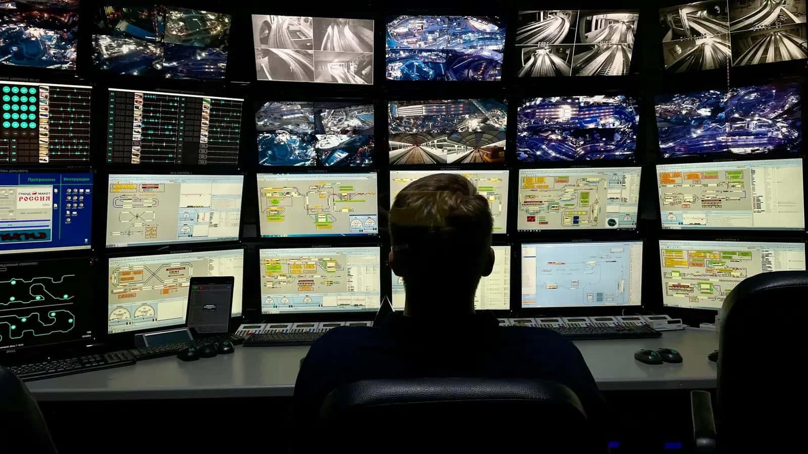 Opérateur face à un mur d'écrans de surveillance dans un centre de supervision