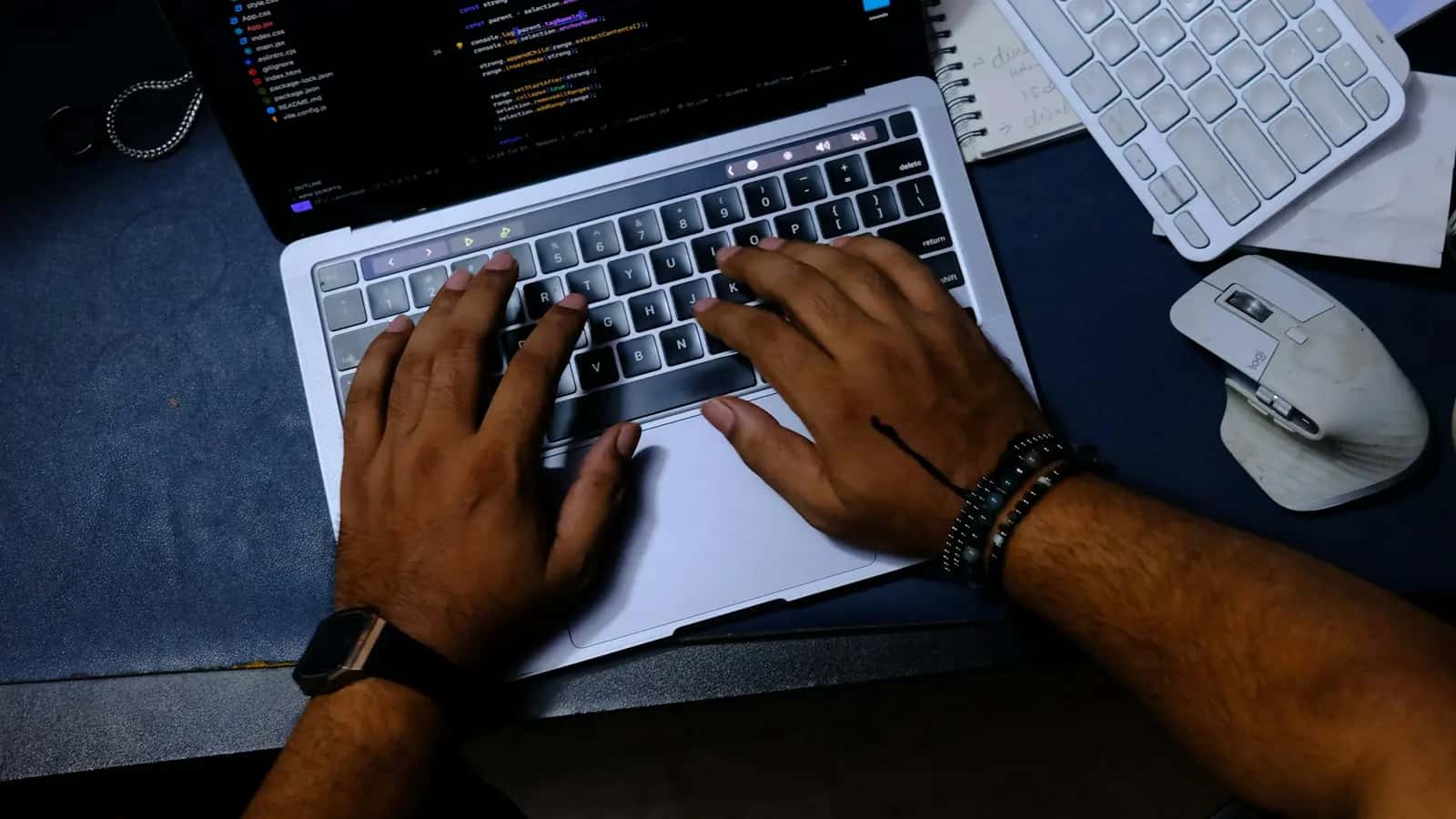Vue de dessus de mains tapant sur un ordinateur portable affichant du code