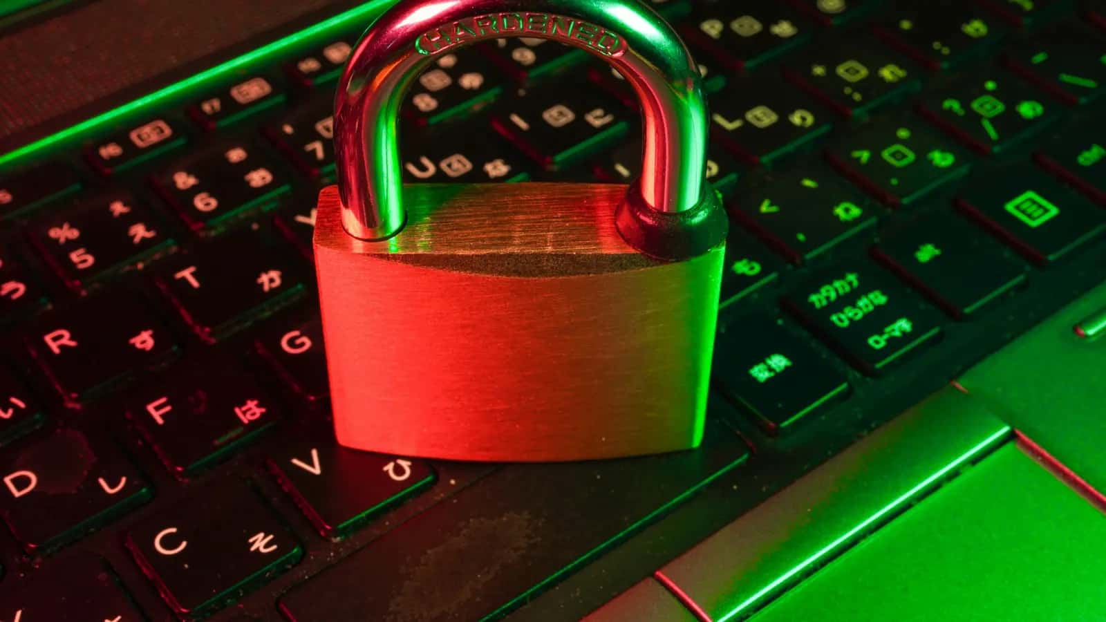 Cadenas rouge posé sur un clavier d'ordinateur rétroéclairé en vert, symbole de sécurité