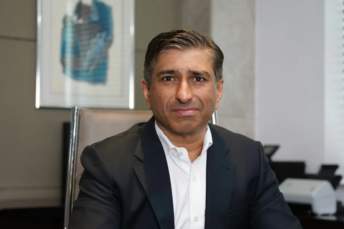 Portrait d'un dirigeant en veste sombre assis à son bureau