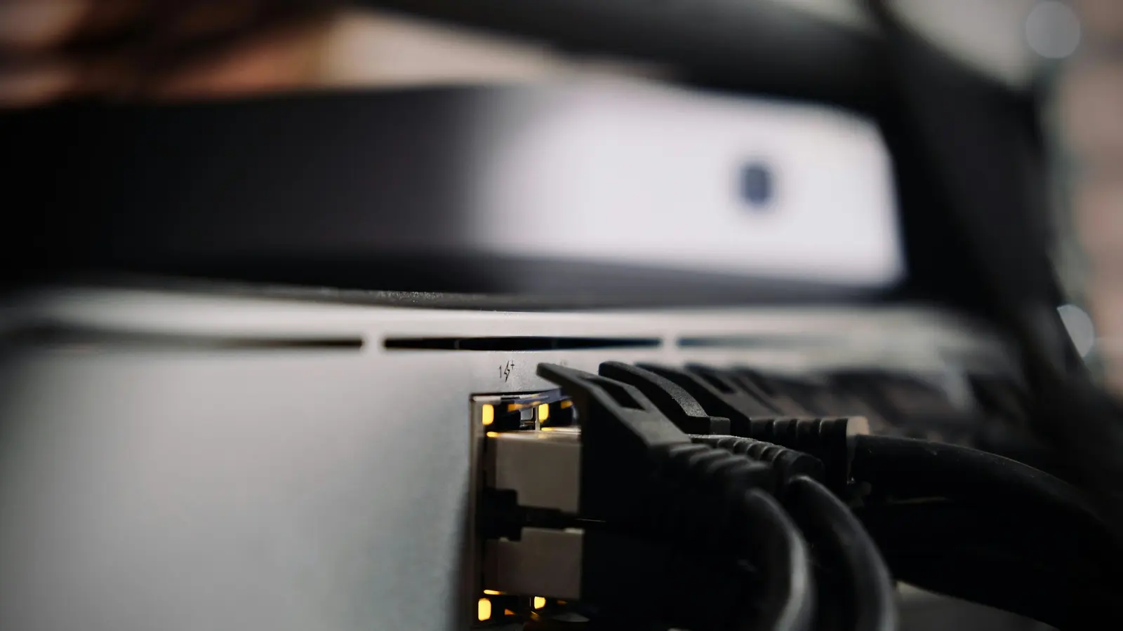Câbles Ethernet noirs branchés à l'arrière d'un équipement réseau